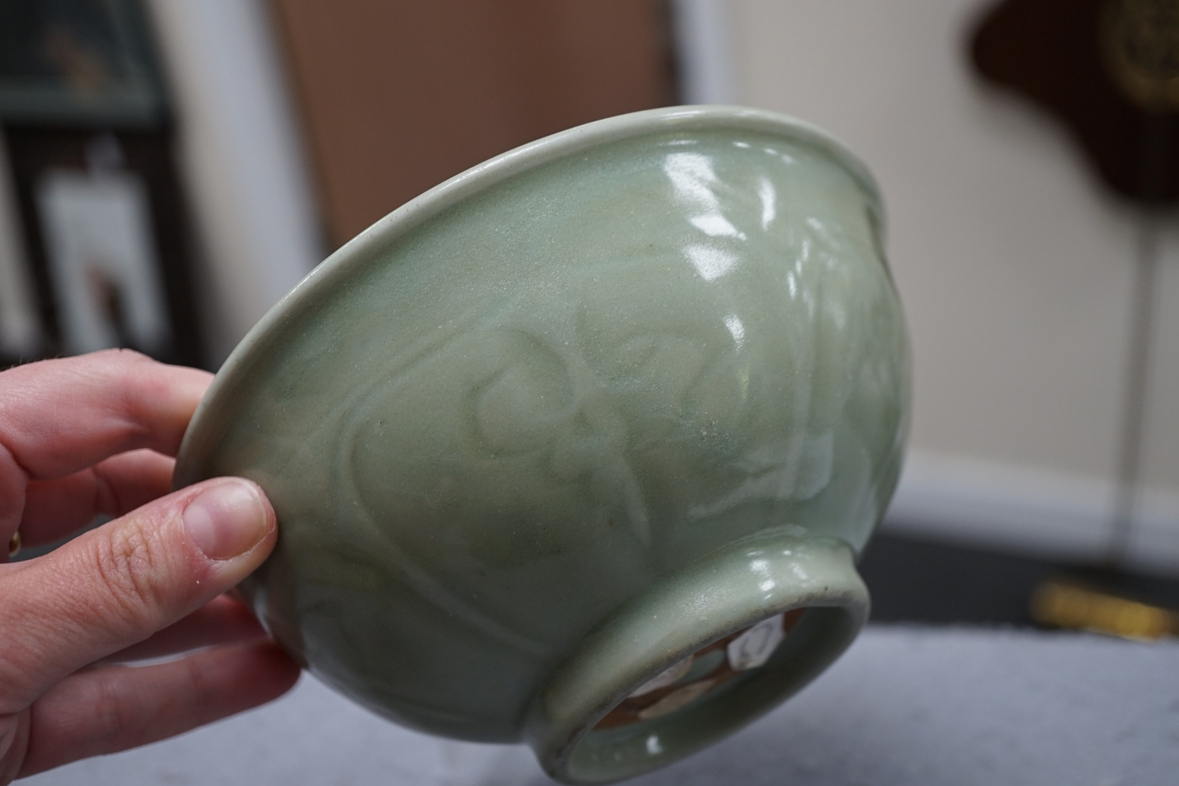 A Chinese Longquan celadon bowl, the interior carved with lotus flowers and the exterior with foliate lappets, 15.2cm diameter., Provenance - Robert Ricketts collection, formerly sold by Robert McPherson, London and S. M